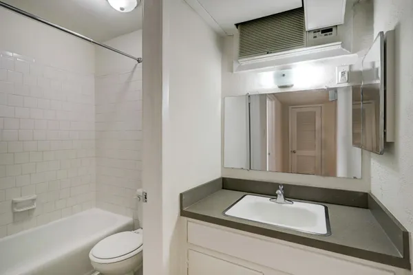 a bathroom with a granite countertop sink toilet and shower