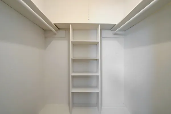 a view of walk in closet with empty racks
