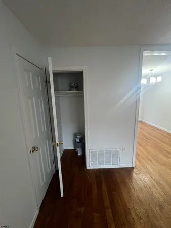 a view of walk in closet with empty tub and wooden floor
