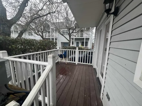a view of balcony with wooden floor and fence and a floor to ceiling window