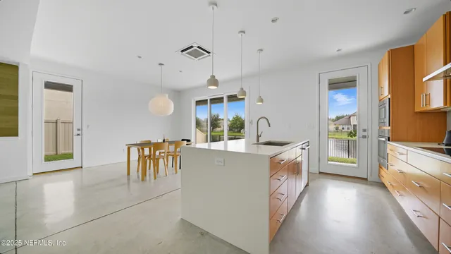 a kitchen with white cabinets and dining table chair