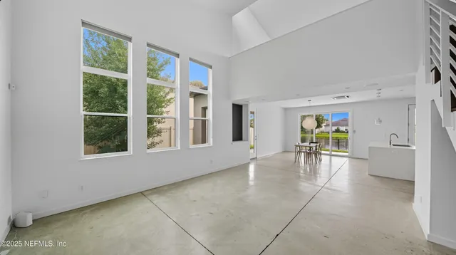 a view of a kitchen with kitchen island a large window cabinets a sink and stainless steel appliances