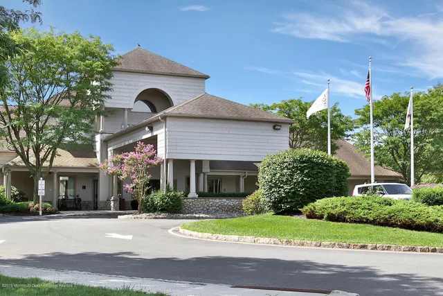 a front view of a house with a yard and potted plants