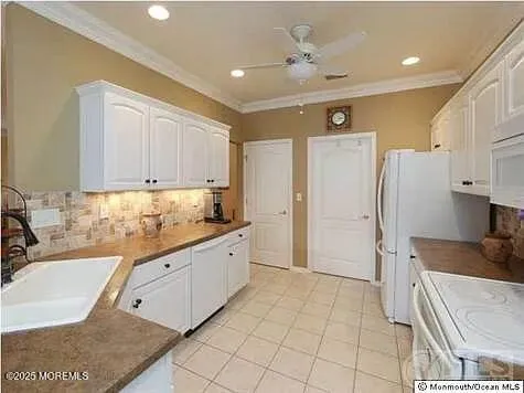 a large kitchen with stainless steel appliances kitchen island granite countertop a refrigerator and a sink