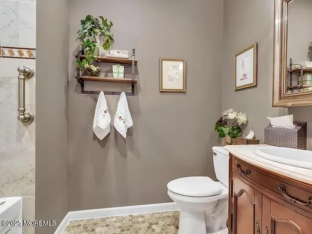 a white toilet sitting next to a bathroom sink