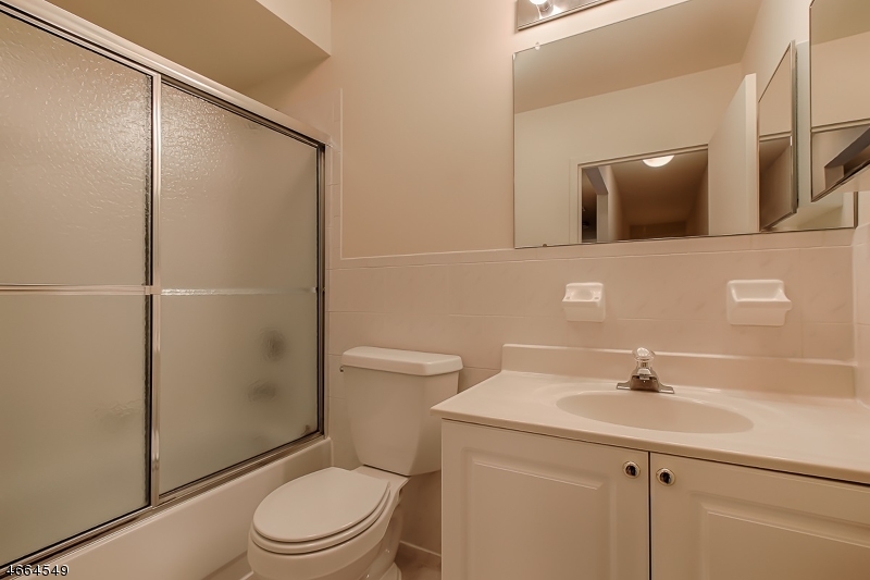 1000 Gates Court, Unit 1047 Morris Plains, NJ 07950 - Photo 15 of 21 a bathroom with a sink toilet and shower