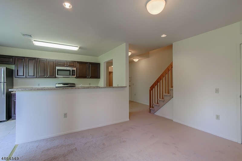 1000 Gates Court, Unit 1047 Morris Plains, NJ 07950 - Photo 4 of 21 a kitchen with stainless steel appliances granite countertop a refrigerator a stove and a sink with granite countertops