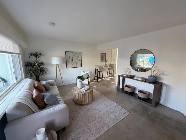 a living room with furniture and a mirror