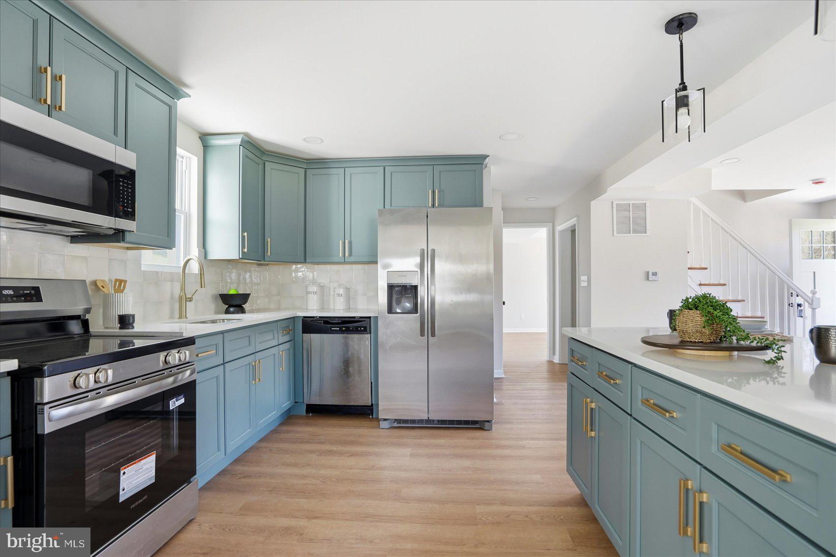 2105 Stringtown Road Sparks Glencoe, MD 21152 - Photo 12 of 57 a kitchen with stainless steel appliances granite countertop a stove a sink dishwasher a refrigerator and a microwave oven with wooden floor
