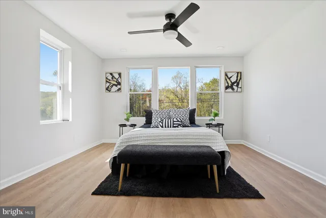 a bedroom with a bed two lamps and a large window