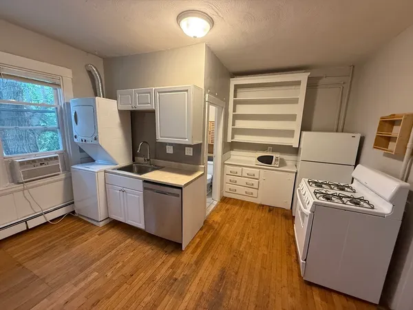 a kitchen with wooden floors and white appliances