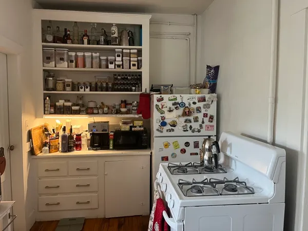a kitchen with white cabinets and a stove