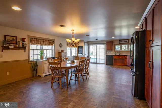 a kitchen with stainless steel appliances granite countertop wooden cabinets a stove a sink and a large window