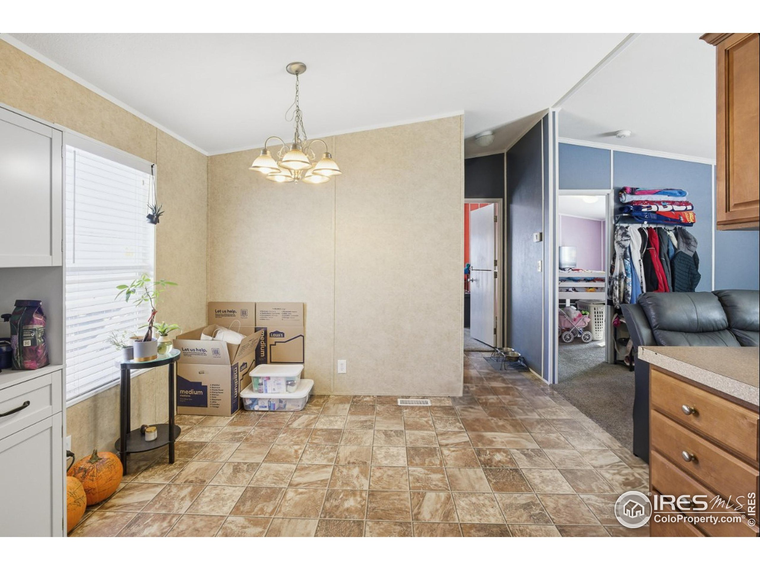 2500 East Harmony Road, Unit 84 Fort Collins, CO 80528 - Photo 11 of 18 a living room with furniture and a chandelier
