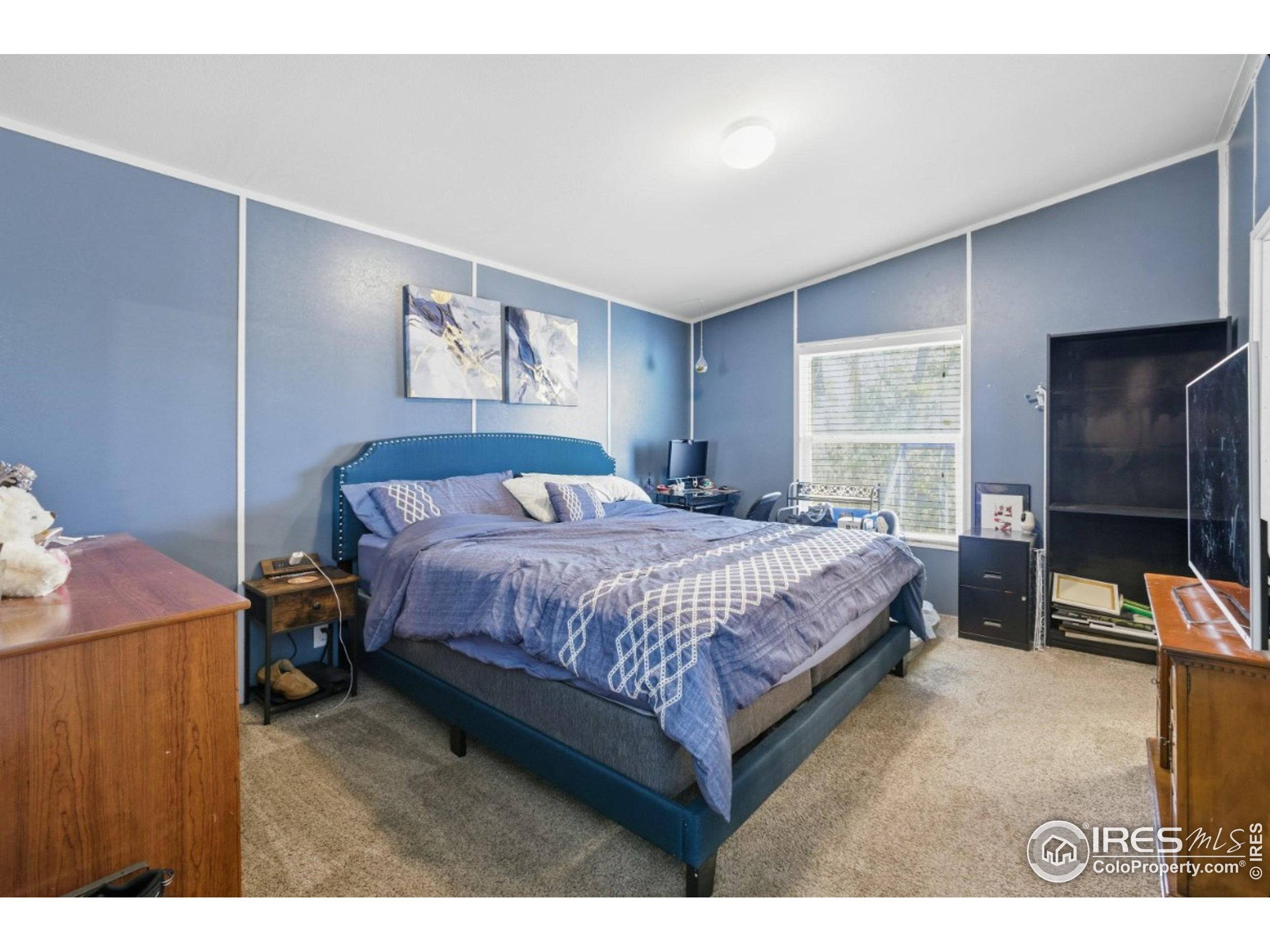 2500 East Harmony Road, Unit 84 Fort Collins, CO 80528 - Photo 12 of 18 a bedroom with a bed and a flat screen tv