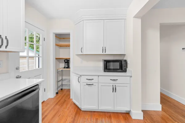 a kitchen with white cabinets and sink