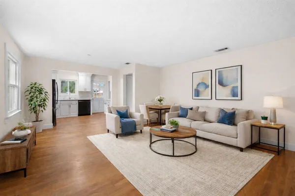 a living room with furniture and view of kitchen