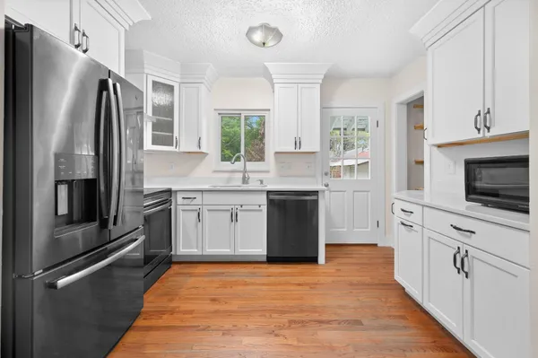 a kitchen with white cabinets stainless steel appliances and a counter space