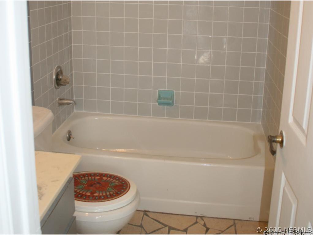 2429 Unity Tree Drive Edgewater, FL 32141 - Photo 19 of 24 a white bath tub sitting next to a white toilet and a sink