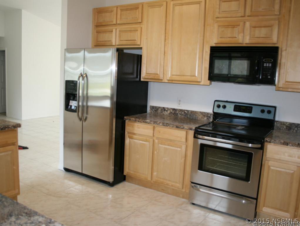 2429 Unity Tree Drive Edgewater, FL 32141 - Photo 5 of 24 a kitchen with stainless steel appliances granite countertop a stove microwave and refrigerator