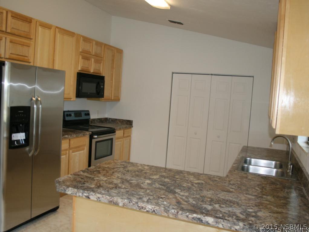 2429 Unity Tree Drive Edgewater, FL 32141 - Photo 6 of 24 a kitchen with kitchen island a sink stainless steel appliances and cabinets