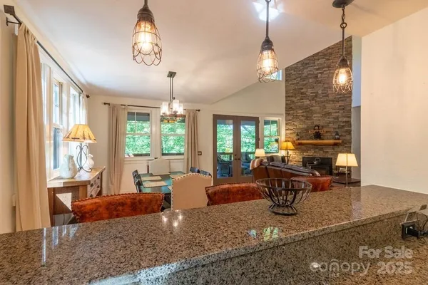 a living room with couches chairs and a dining table with wooden floor