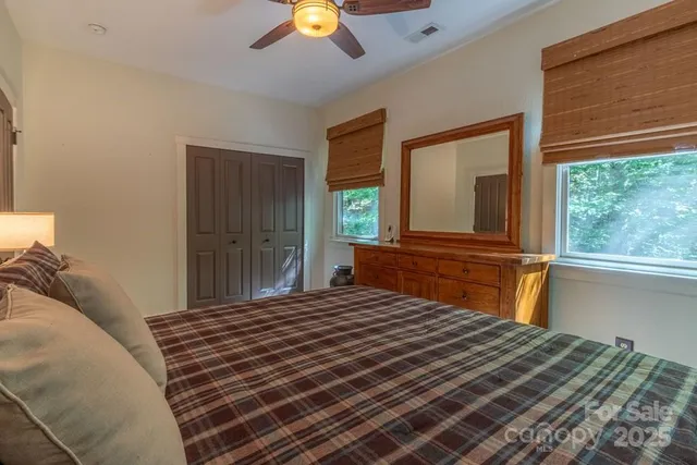 a bedroom with a bed and a large window