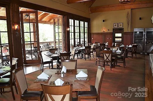 a dining room with furniture floor to ceiling windows and potted plants