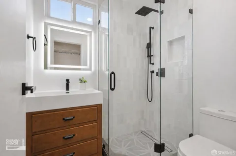 a bathroom with a sink a toilet and shower