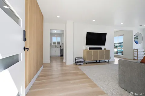 a view of a livingroom with wooden floor and a flat screen tv