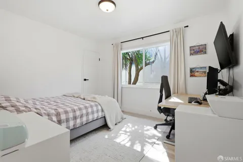 a bedroom with a bed and a flat screen tv