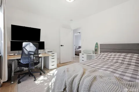 a bedroom with a bed and a flat screen tv