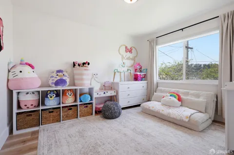 a living room with furniture toys and a book shelf