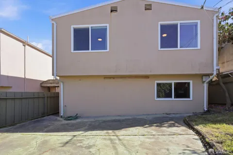 a backyard of a house with yard and wooden fence