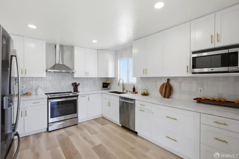 a kitchen with stainless steel appliances granite countertop a stove a sink and a microwave