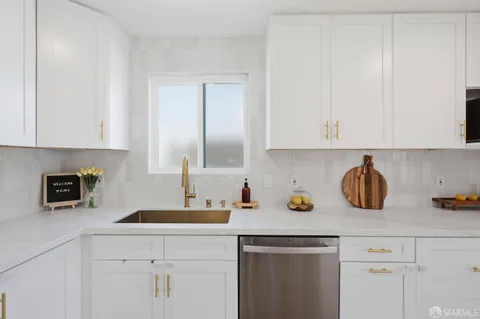 a kitchen with a sink a microwave and cabinets