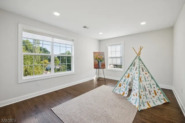 a view of a bedroom with wooden floor and windows