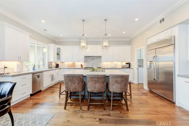 a kitchen with kitchen island granite countertop a counter top space a sink stainless steel appliances and cabinets