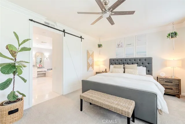 a bedroom with a bed table and a potted plant