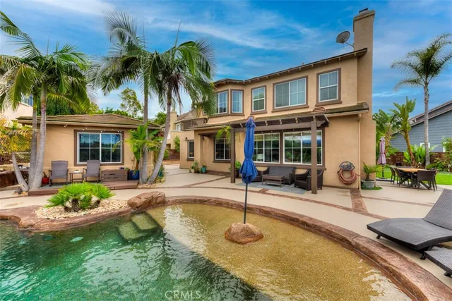 a view of a house with swimming pool and sitting area
