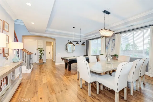 a view of a dining room and livingroom with furniture wooden floor a chandelier