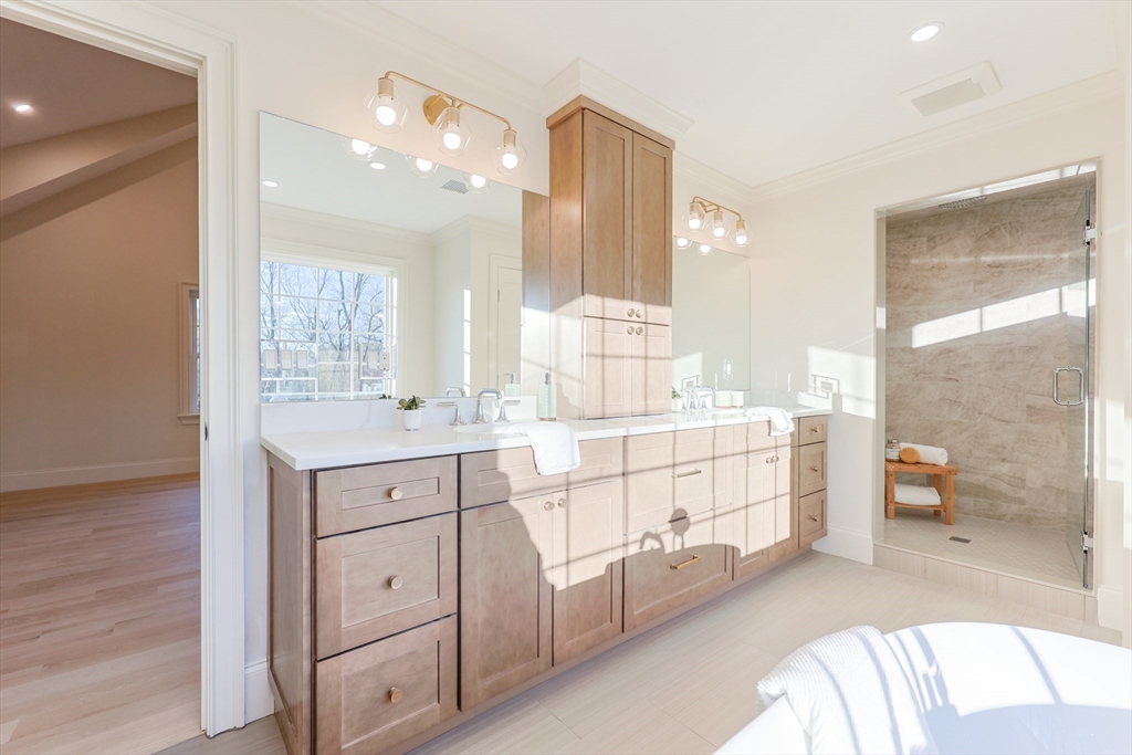 54 Woodland Road Scituate, MA 02066 - Photo 16 of 30 a spacious bathroom with a double vanity sink a mirror and a bathtub