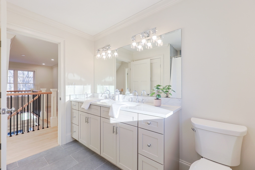 54 Woodland Road Scituate, MA 02066 - Photo 23 of 30 a bathroom with a double vanity sink toilet and a mirror