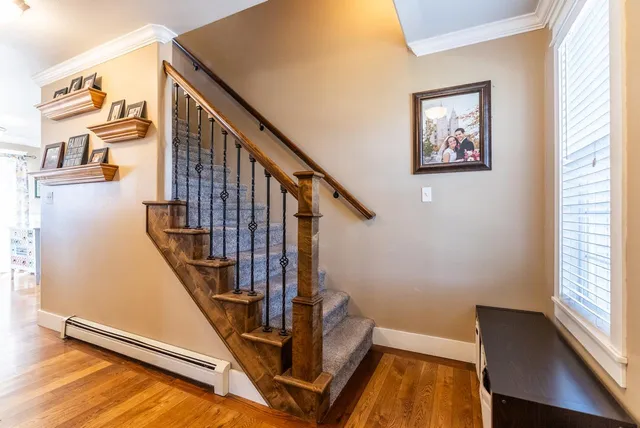 a view of staircase with lots of frames on wall and a window
