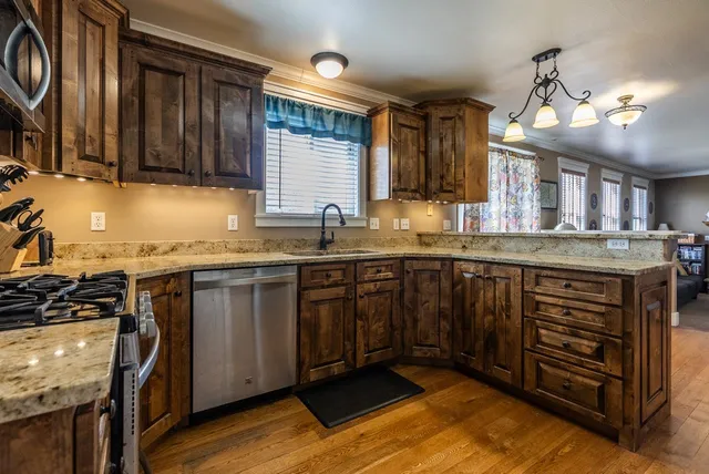 a kitchen with stainless steel appliances granite countertop a sink stove and cabinets