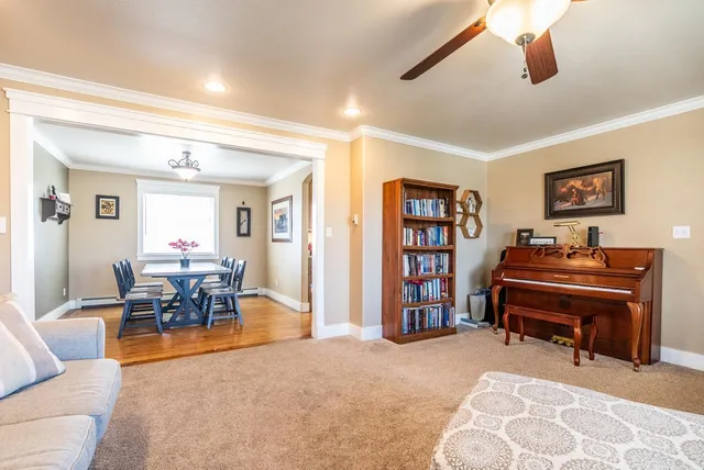 a living room with furniture a piano and a bookshelf