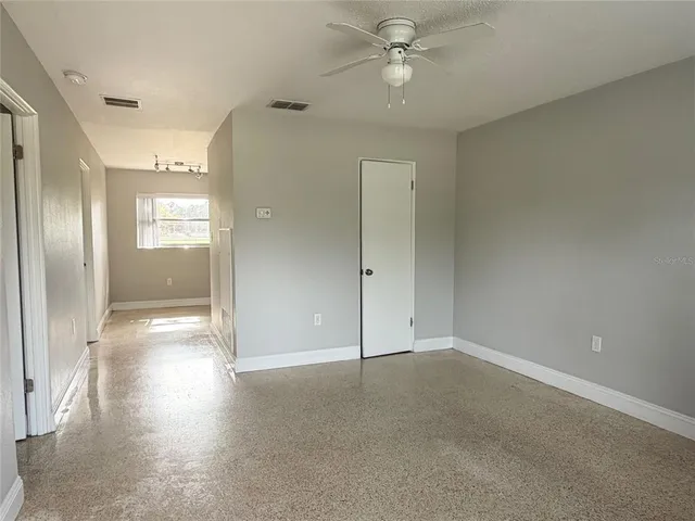 an empty room with fan and entrance
