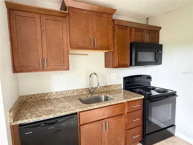 a kitchen with stainless steel appliances granite countertop a sink stove and microwave