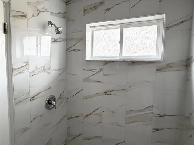 a bathroom with a window shower and vanity