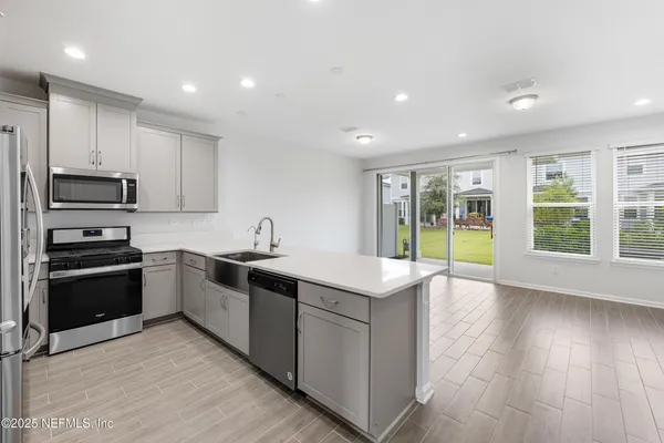 a large kitchen with stainless steel appliances granite countertop a stove and a sink